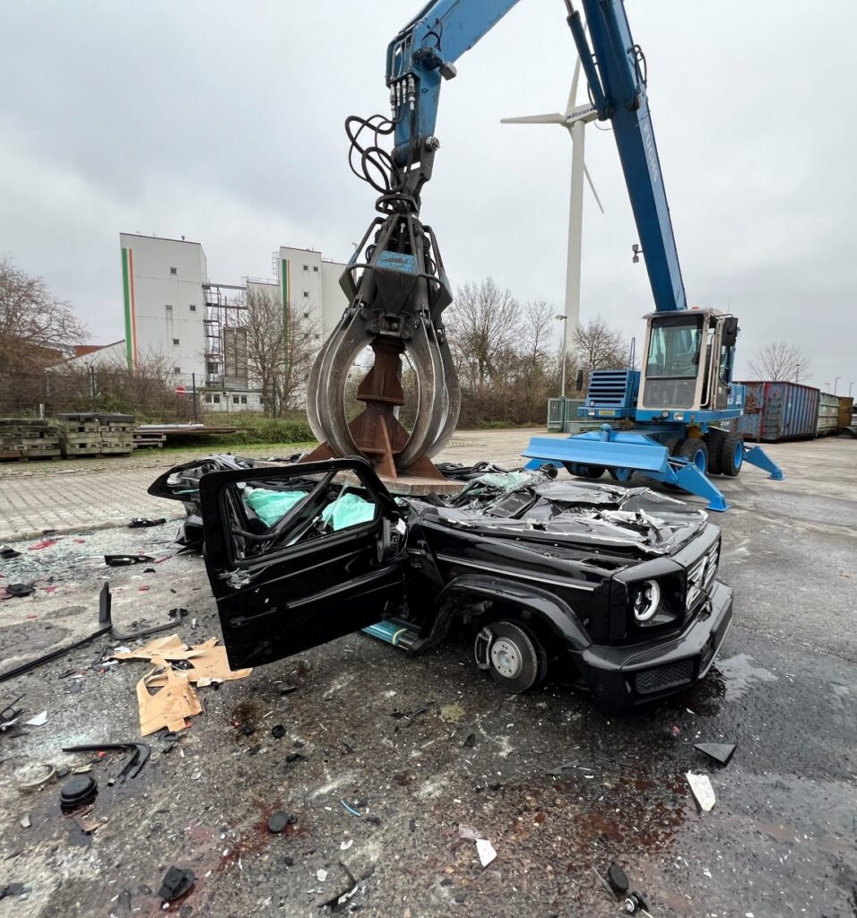 Greifer bei der kontrollierten Verschrottung eines Fahrzeugs